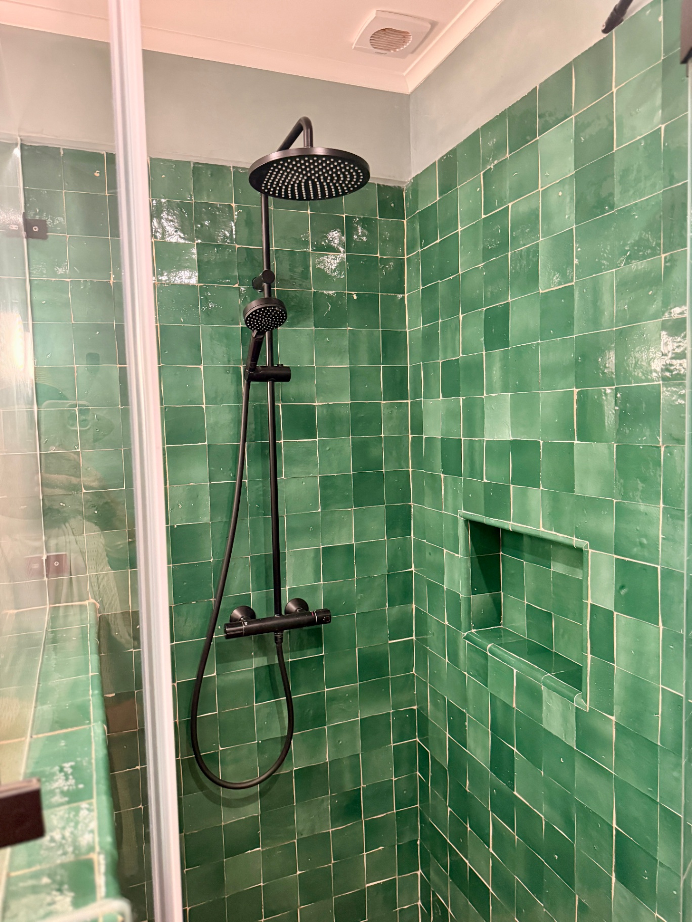 Green zellige tile shower with black fixtures