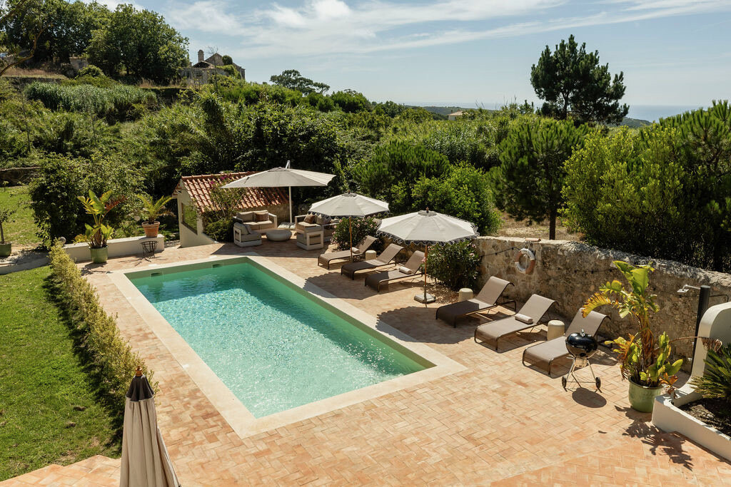 The pool and terracotta terrace seen from above, hills behind