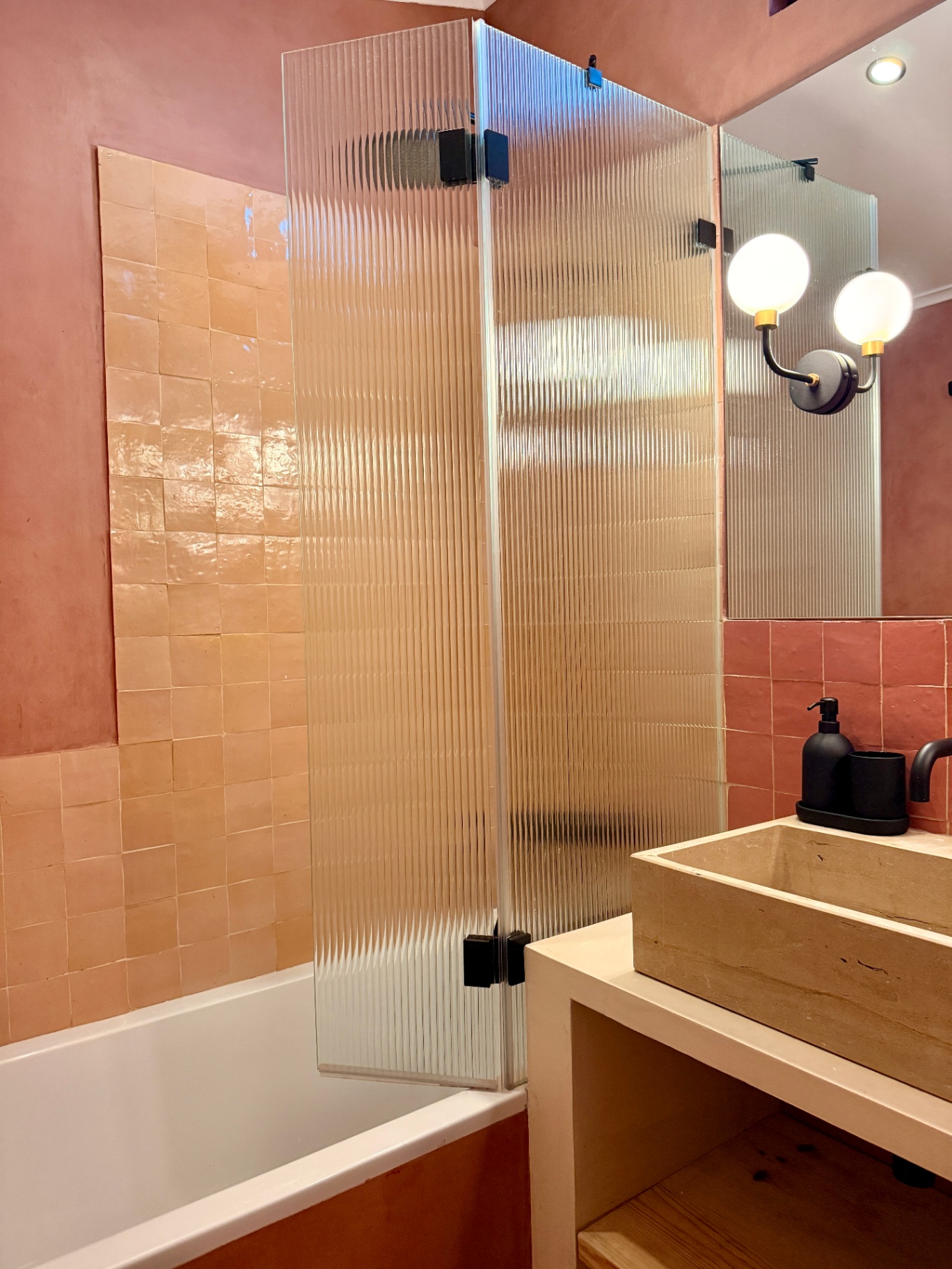 Terracotta bathroom with stone sink and fluted glass shower screen