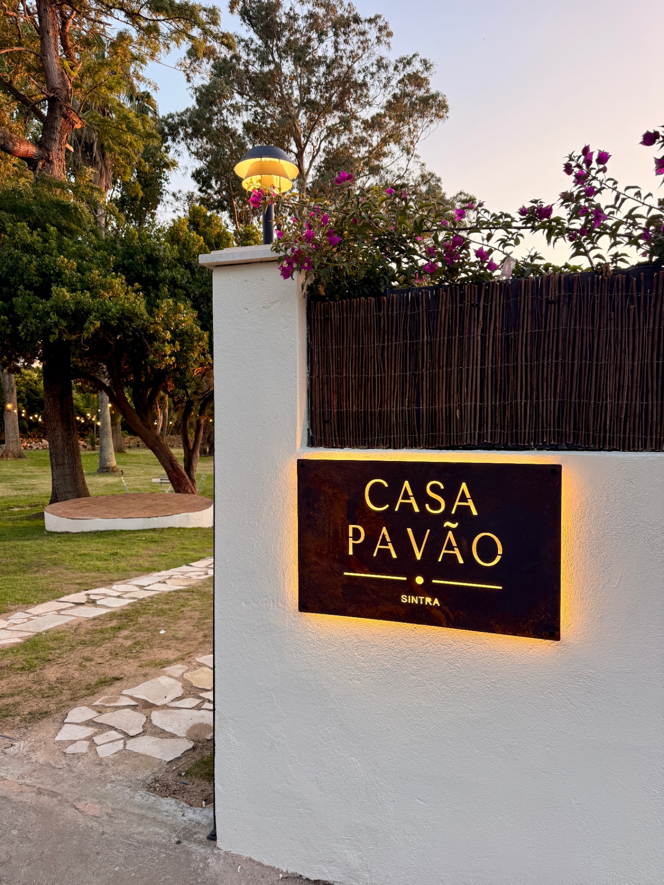Casa Pavão entrance sign glowing at dusk