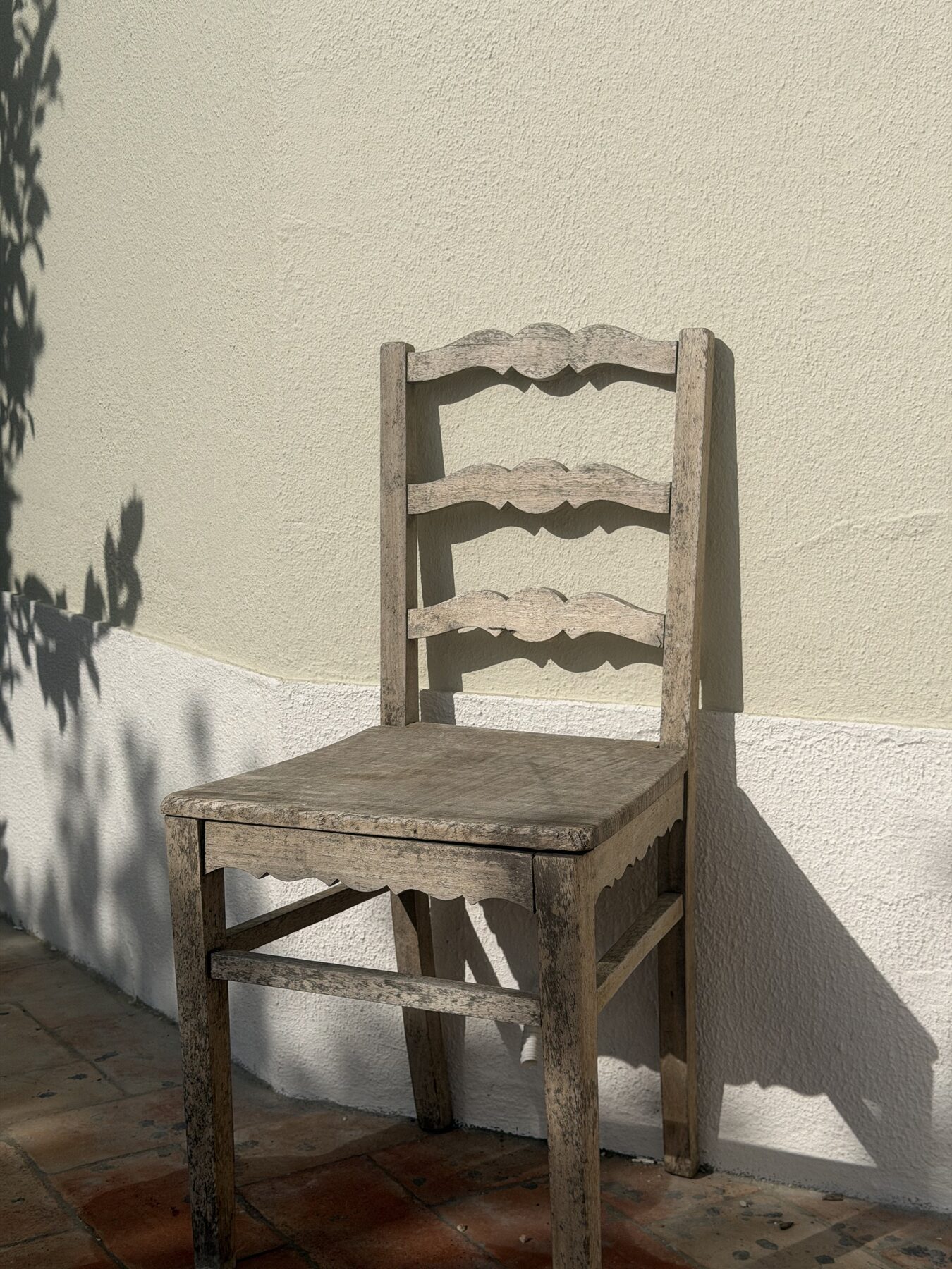 Weathered wooden chair on a sunlit terrace